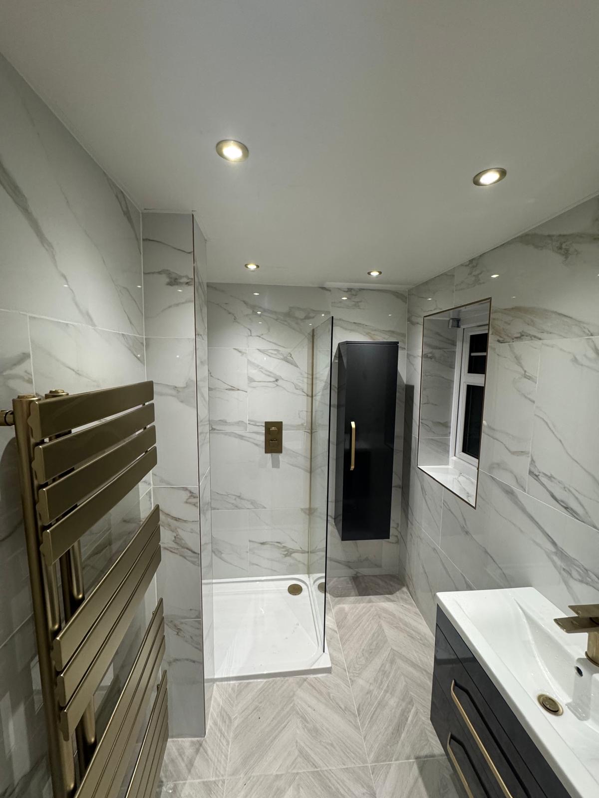 Finished shower room with marble-effect wall tiles, a tiled niche and a herringbone-effect floor